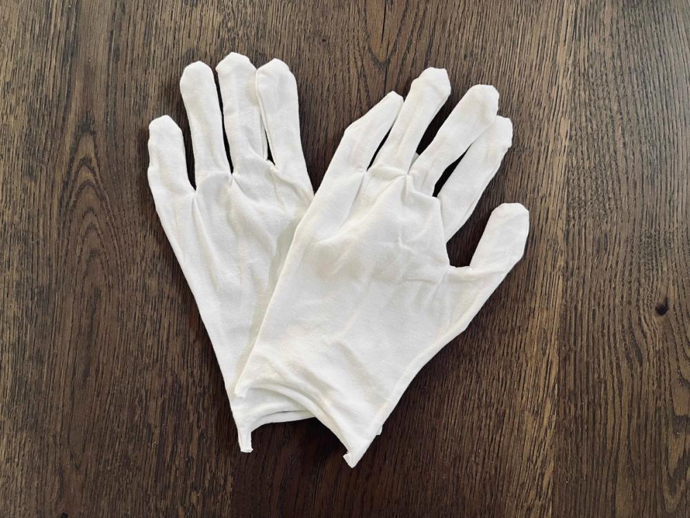 A pair of white cotton gloves helps stop the transfer of natural oils from your hands to the print